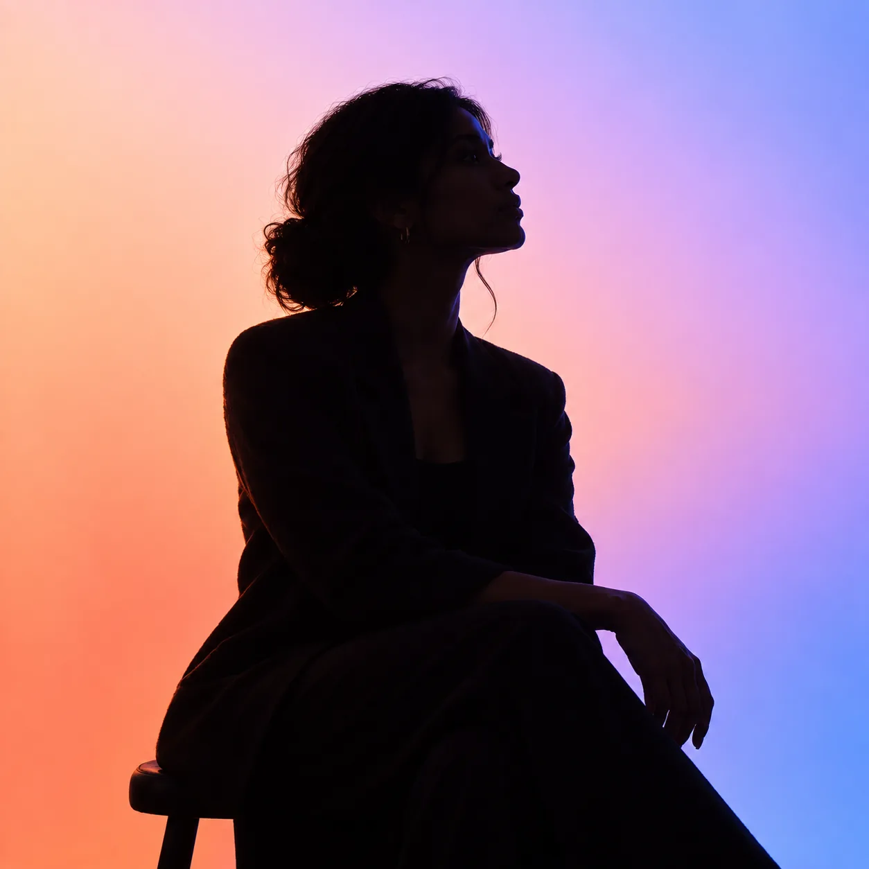 Professionnelle de la communication en silhouette sur fond dégradé orange et bleu, agence Les Idéaux à Lyon et Annecy